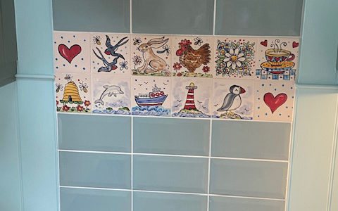 selection of hand painted tiles on cooker splashback