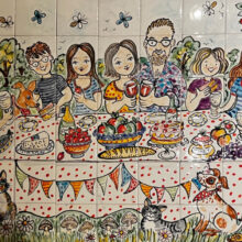 Hand painted tile mural of family having picnic in garden