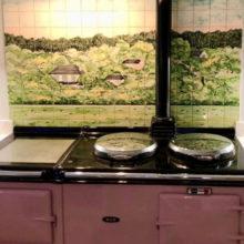 Green wood tile mural behind Aga range cooker